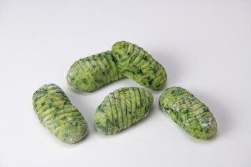 Pile of green spinach gnocchi dough dumplings isolated over the white background, High quality photo