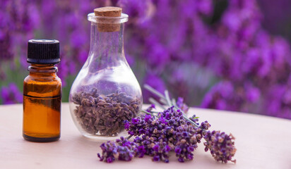 jars with lavender oil, lavender flowers, on the background of a lavender field.