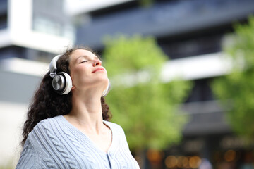 Woman breathing with headphones in the street