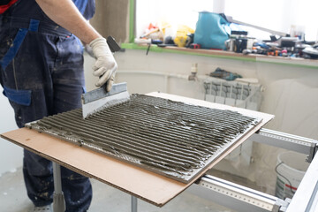 applying adhesive to tiles. comb trowel for applying glue 