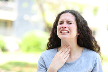 Fototapeta na wymiar Woman suffering sore throat in the street