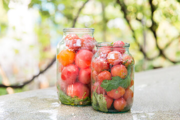 Glass jars with vegetables (tomatoes) in nature on a rustic kitchen table. Healthy homemade food. concept of saving the agricultural seasonal harvest.	