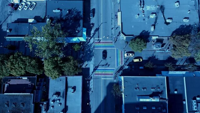 Vancouver Davie Village Jim Devo square aerial drone hold overlooking birds eye view top of the retail business in between iconic Hamburger diner and convenient store with 3 rainbow flag roads at Bute