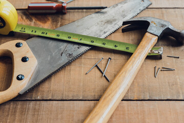 Close up of woodworking tools scattered on a wooden table.