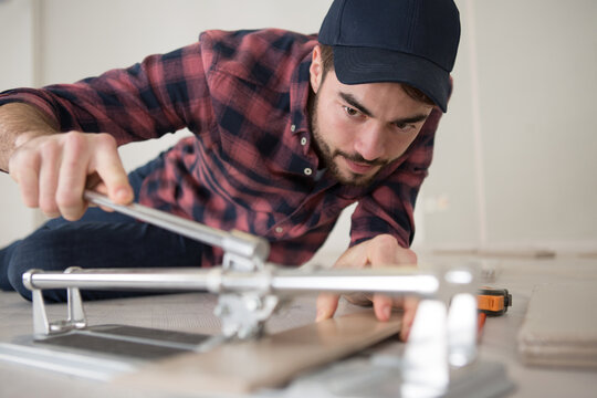 close-up of a man cutting ceramic tiles with handy machine