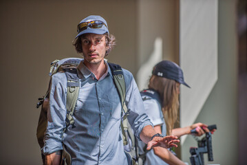 Two photographers in blue shirt getting camera gear ready in sunlight