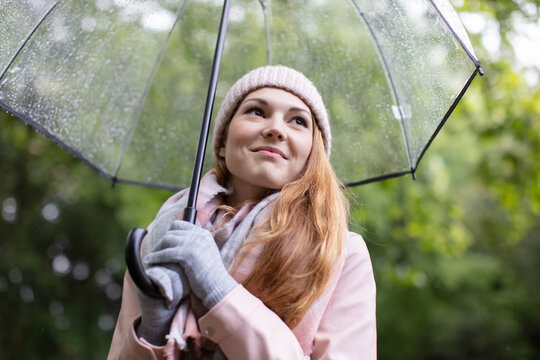 spring beautiful romantic red haired girl with transparent umbrella