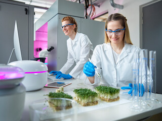Smiling women wearing lab coat working in laboratory