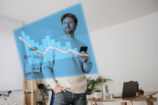 Businessman with smart phone looking at virtual graphs