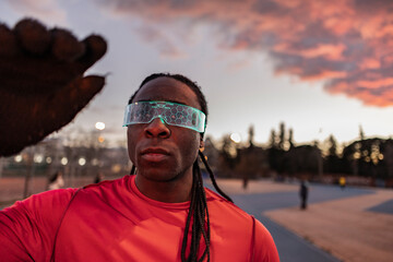 Young athlete wearing illuminated smart glasses at sunset