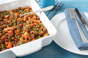 Minced meat stew with peas and carrots in a bowl