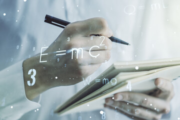 Creative scientific formula illustration with man hand writing in diary on background, science and research concept. Multiexposure