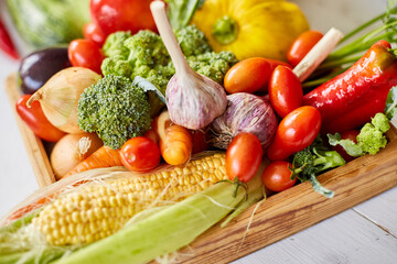 Wooden box with different fresh farm vegetables on the white background, Autumn harvest and healthy organic bio food concept, Garden produce and harvested vegetable