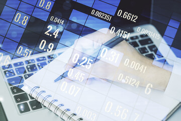 Abstract creative stats data concept with hand writing in notebook on background with laptop. Multiexposure