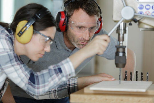 Two Carpenters Work Using A Milling Machine Indoors