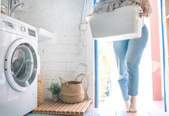 Unrecognizable woman doing laundry with washing machine at home, eco cleaning housework concept