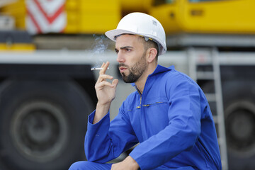 a male builder smoking outdoors