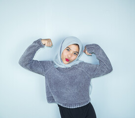 Excited Asian Muslim woman celebrating victory isolated over white background