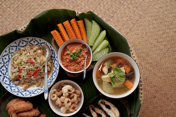 `Closeup Food scene of Local Thai Food Northern Style - Fish Chicken Pork  Fried , Soup , Stir Fried Vegetable and chili sauce  seen From Doing SaKad Pua Nan Thailand 