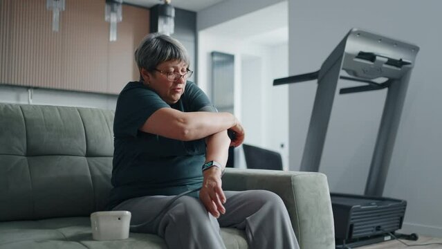 Senior Woman With Hypertension Taking Blood Pressure At Home, Modern Medical Device For Domestic Use