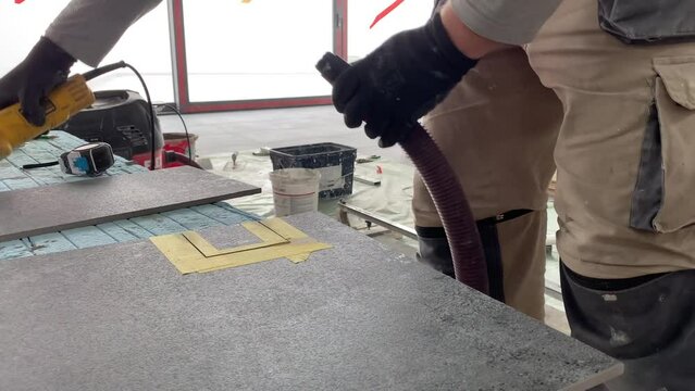 Builder tiler measures the tiles and cuts them with a diamond cutter