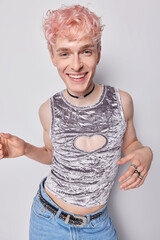 Cheerful carefree homosexual man with pink hair dances and has fun romantic mood dressed in...