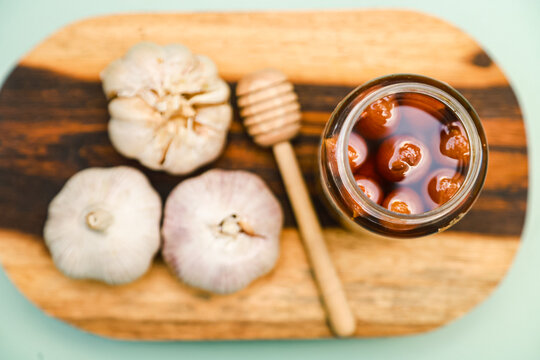 Flat lay of Fermentation between single garlic and honey is packaged in a jar