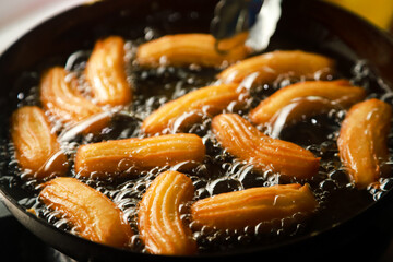 churros dough fried in hot oil on a griddle