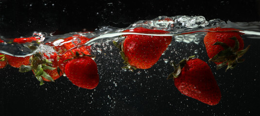 Tasty strawberries in water, concept of freshness