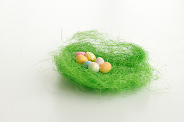 Easter bunny rabbit statuette. Close up, copy space. Easter eggs. Chicken eggs, twigs with green leaves on the hay. Easter holiday concept background. Copy space