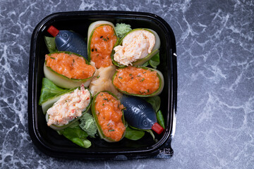 set of sushi rolls with seafood on a black stone background