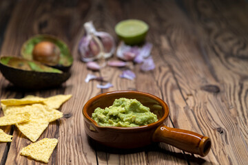 avocado dip flavored with garlic, chili, pepper, and lime juice with corn nachos