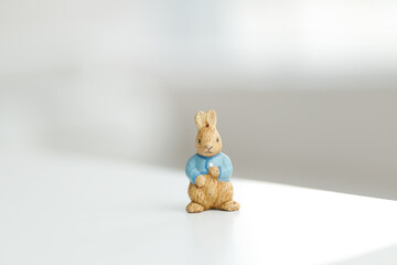 Handmade Easter bunny. Blurred background. Easter toys. Wooden Easter eggs on white background, copy space.