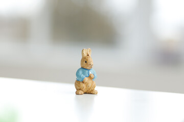 Handmade Easter bunny. Blurred background. Easter toys. Wooden Easter eggs on white background, copy space.