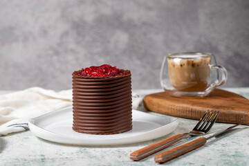 Chocolate and raspberry cake. Patisserie products. Chocolate covered cake on gray background.