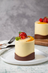 Chocolate and fruit cake. Bakery products. Chocolate covered cake on gray background. Cake made with strawberry, kiwi, raspberry, pear and peach. Close up