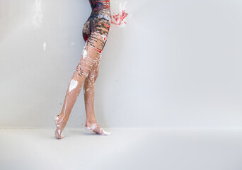 beautiful hip, buttocks, legs and feet of sexy young artistically abstract painted woman in underwear, sportswear, with black, red and white paint