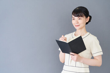 Obraz premium 手帳を書くエステ・美容クリニックの女性