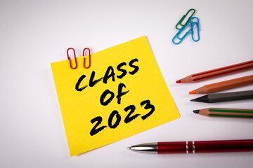 CLASS OF 2023. Notepad and colored pencils on a white background