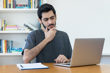 Fototapeta premium Thinking israeli IT specialist at work at computer