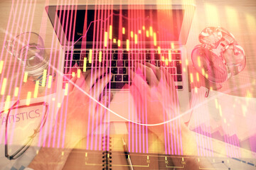 Double exposure of man's hands typing over laptop keyboard and forex chart hologram drawing. Top view. Financial markets concept.
