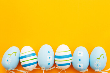 easter colorful handmade painted blue eggs on orange background with copy space