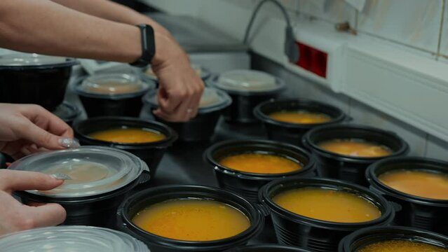 warm food for beggars volunteer packing boxes with soup in a line Humanitarian Aid