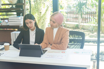 Two brunette business woman, talking, advising each other.