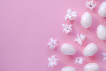 Easter Concept. Pink Easter eggs and natural flowers on a pink background. Flat plan, space for text.