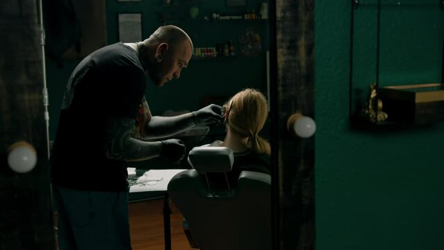 Piercing studio interior - piercing master makes a piercing to a girl ear piercing