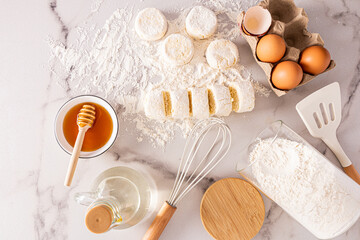 top view of freshly cooked cheesecakes and ingredients for cooking. eggs, honey, butter in a bottle. delicious breakfast.