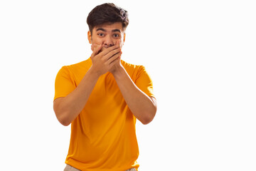 Portrait of surprised man covering mouth against white background