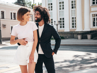 Smiling beautiful woman and her handsome boyfriend. Sexy cheerful multiracial family having tender moments in the street at sunset. Multiethnic models hugging. Embracing each other. Love concept