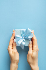 Blue gift box with bow on blue background